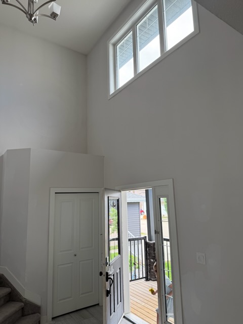 Two-storey foyer with high walls prepared for painting