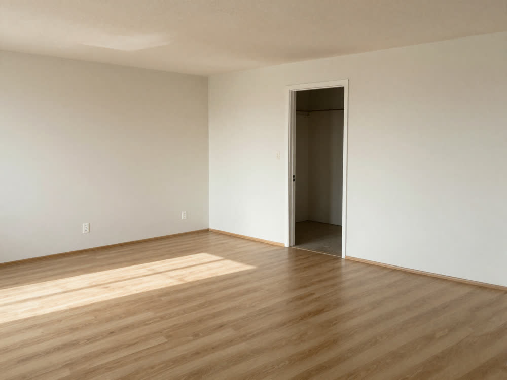 Empty room in a vacant home with bare floors, ready to be repainted