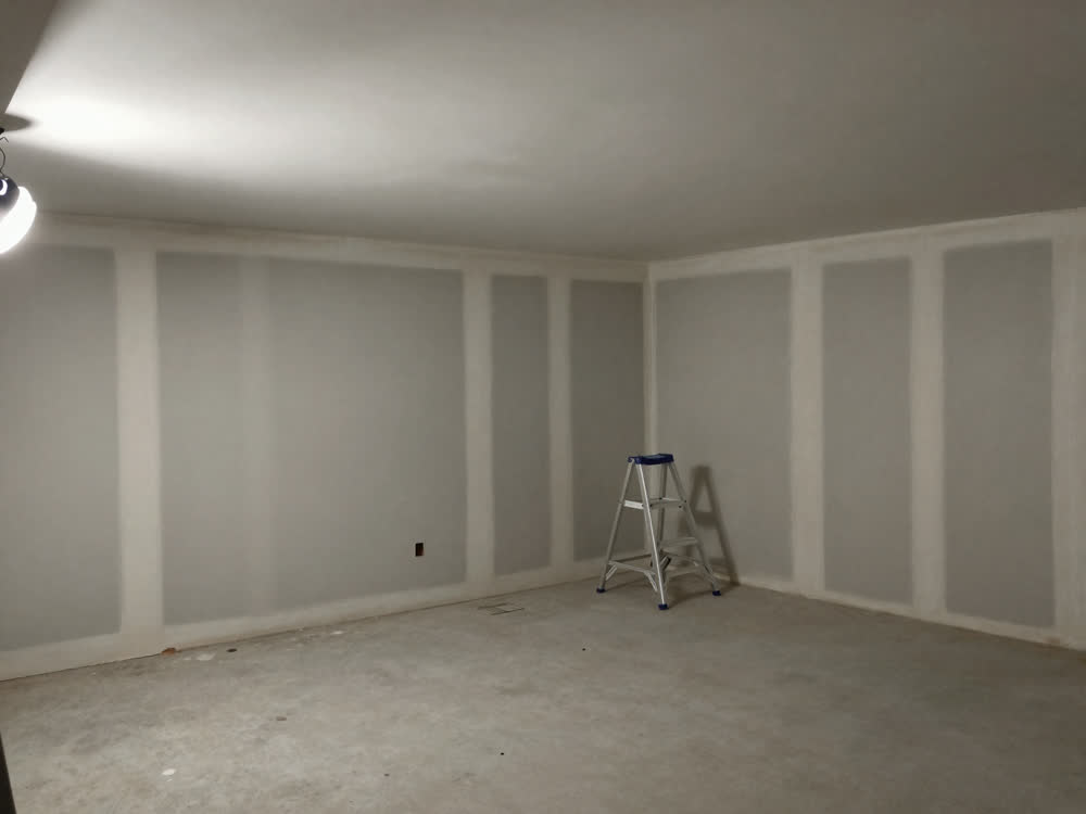 Newly drywalled basement with taped seams ready for priming and paint